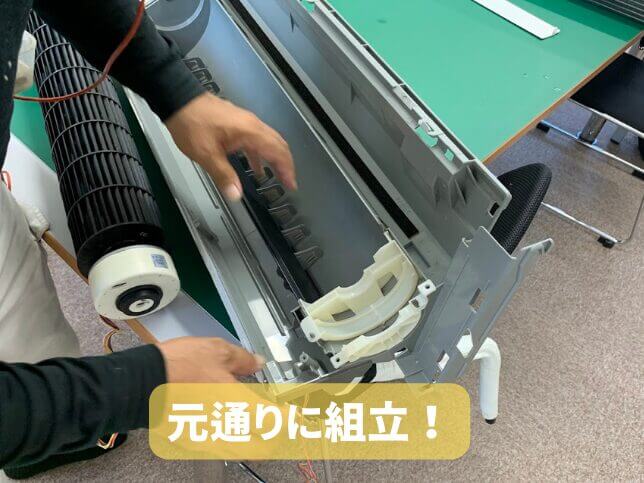 エアコン完全分解クリーニング後に、送風ファンや内部部品を元通りに組み立てている様子。画面下には「元通りに組立!」と表示。