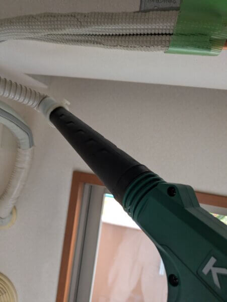 お掃除機能の排気ホース内のホコリをブロワーでお掃除している所
