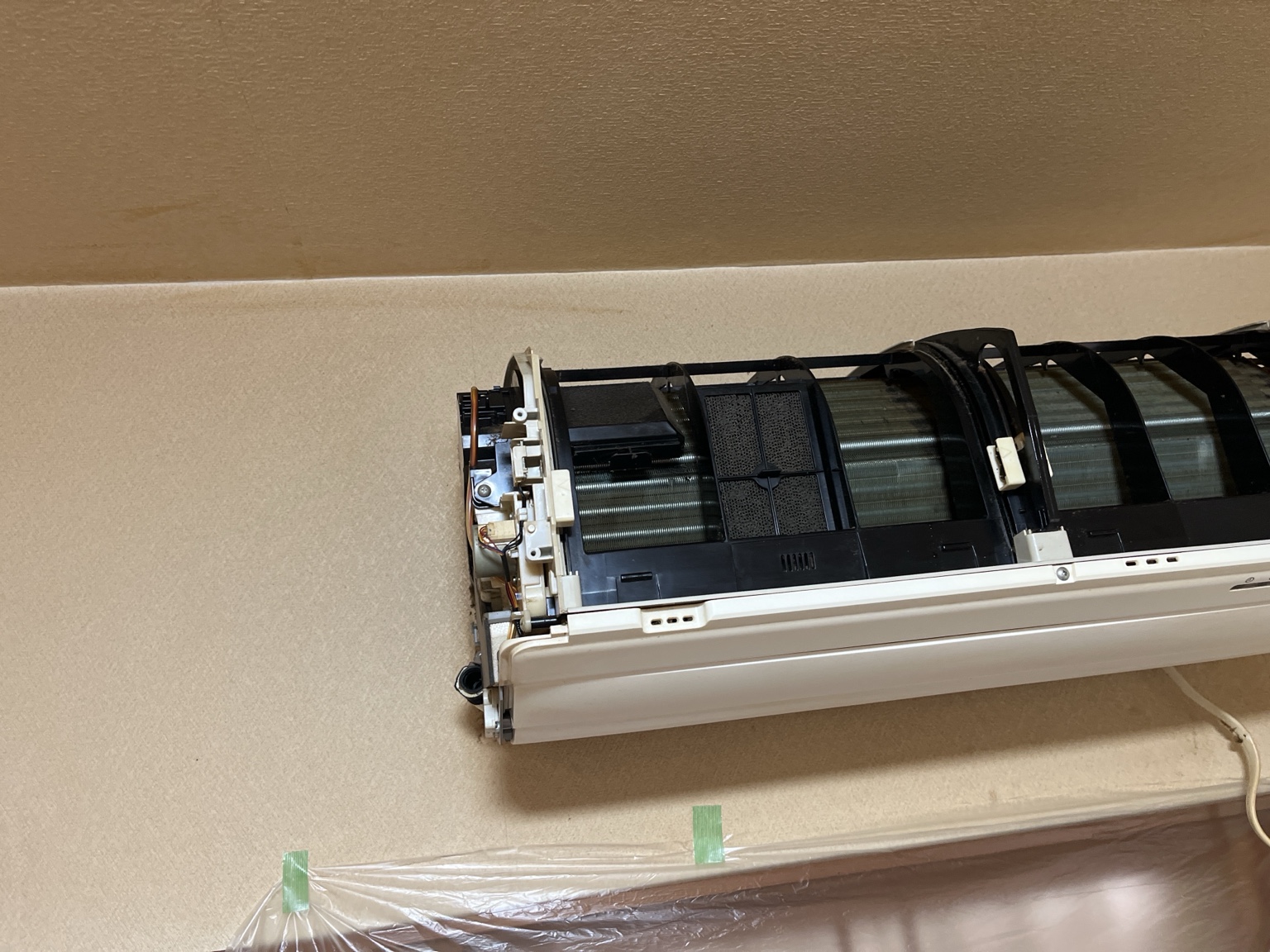 室内機側でドレンホースを外して排水状態を確認する様子