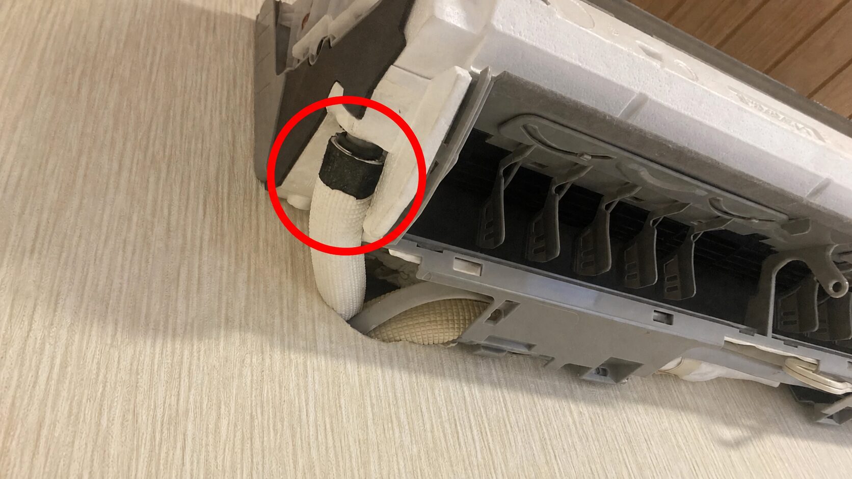 左配管側のドレンホース接続部を赤丸で強調した写真