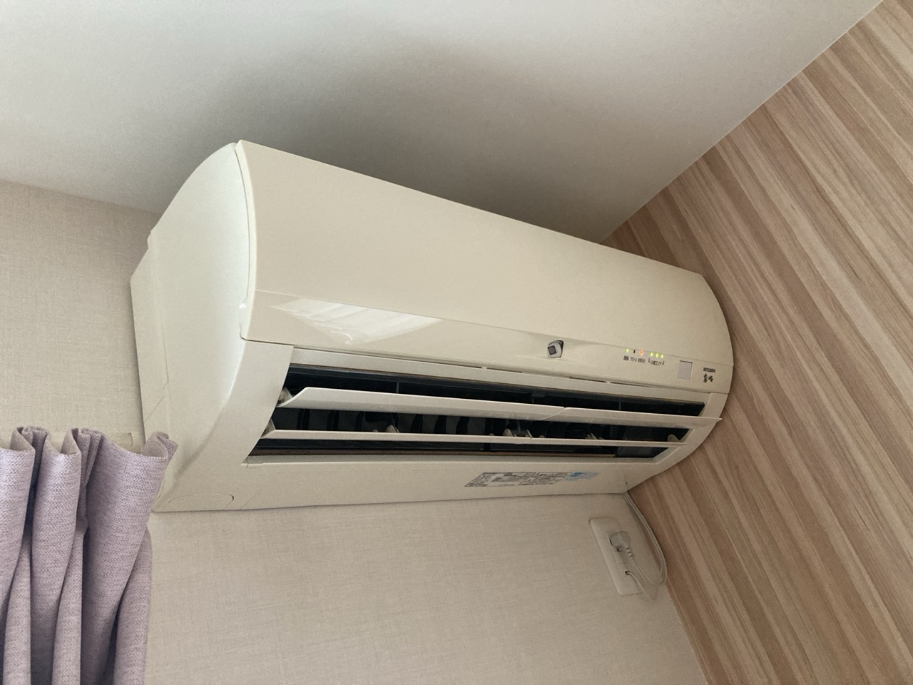 右側が壁に近い位置へ設置された三菱のお掃除機能付きエアコン