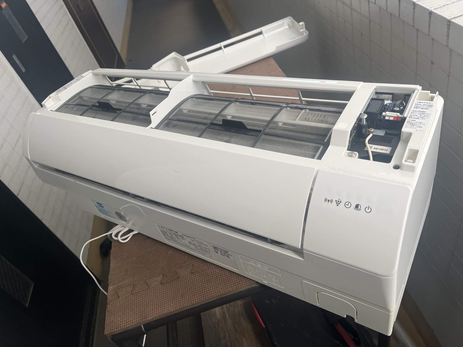 室内機を壁から取り外し、屋外の作業台へ運び出しました。